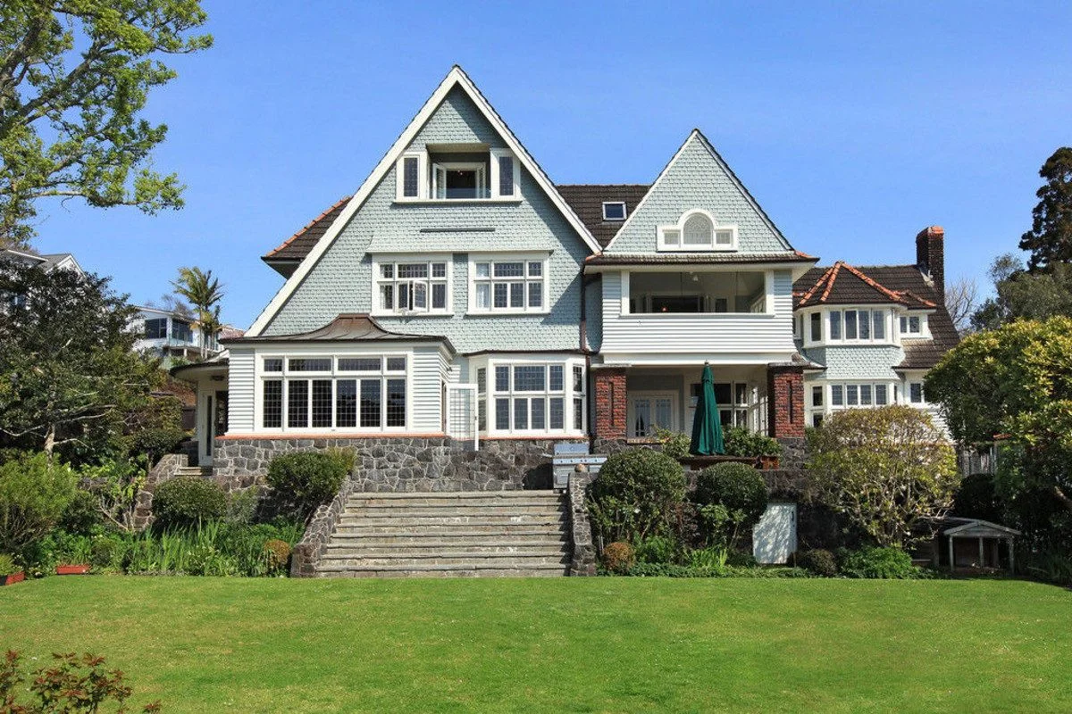 Elegant heritage mansion on Garden Road in Auckland, ranked among the most expensive houses in New Zealand, with gabled rooflines, stone foundations, and manicured gardens.