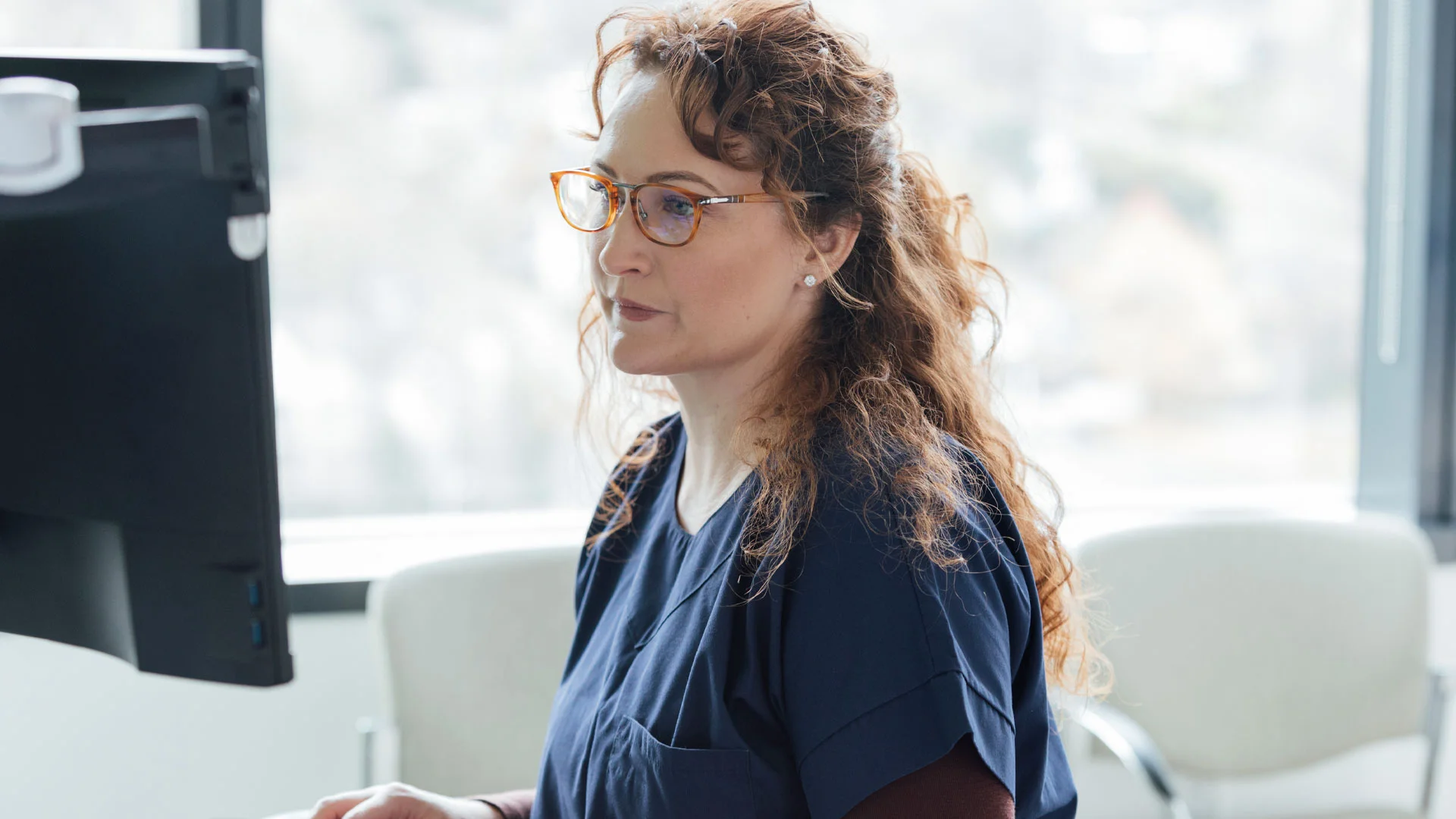 Nurse Practitioner working on a laptop in her office.