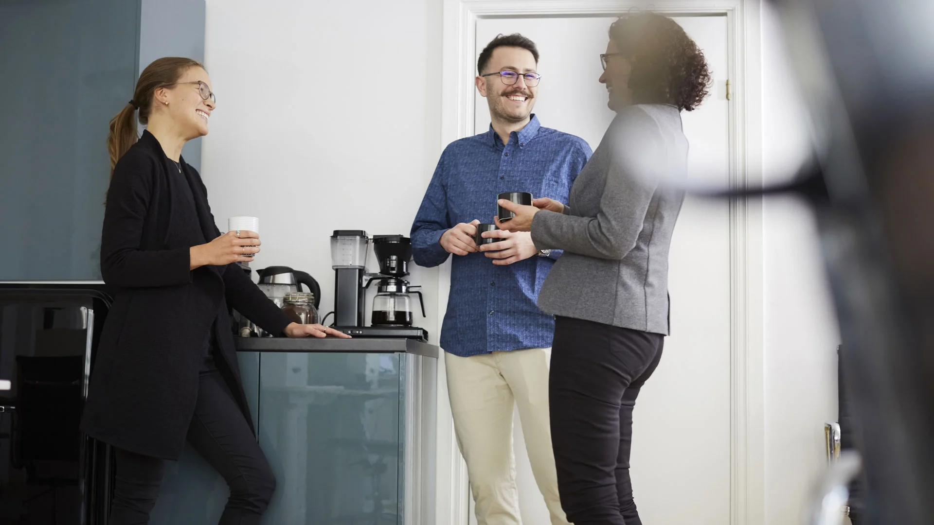 Colleague laughing with friends at work.