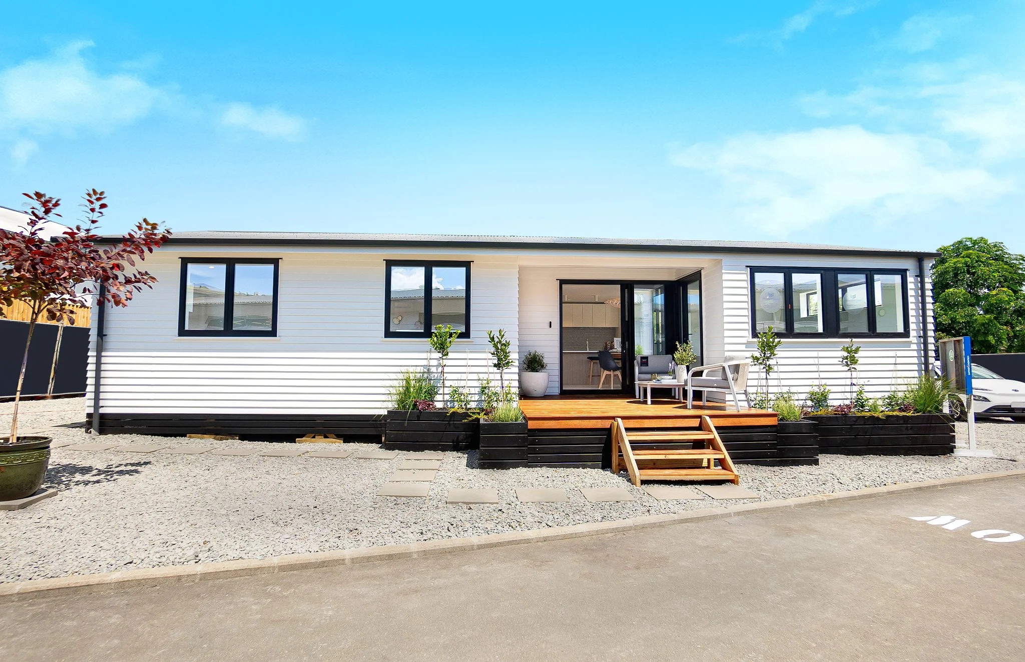 A white modern moveable home complete with a small entrance decking space.