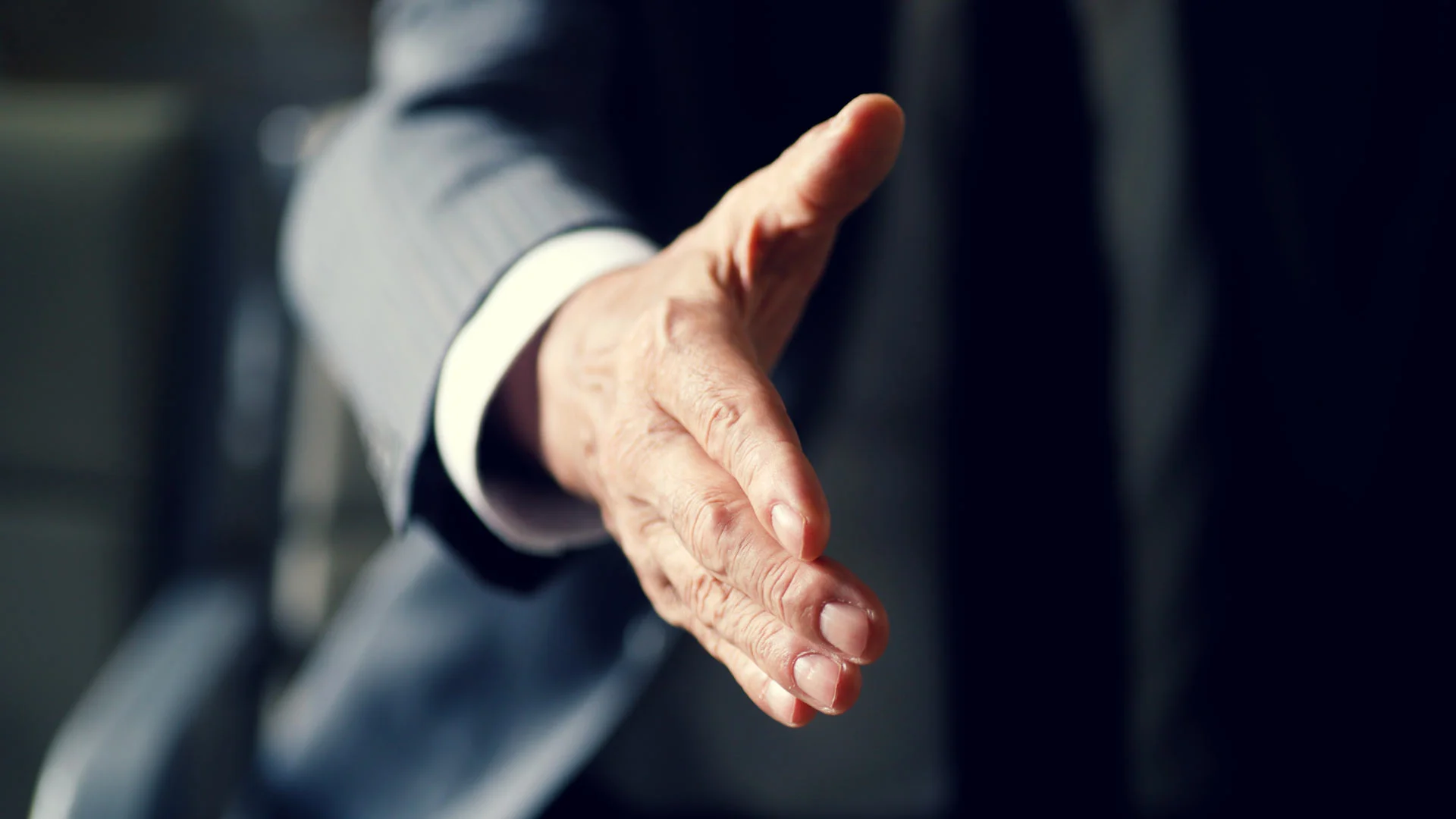 Business man offering his hand to shake.