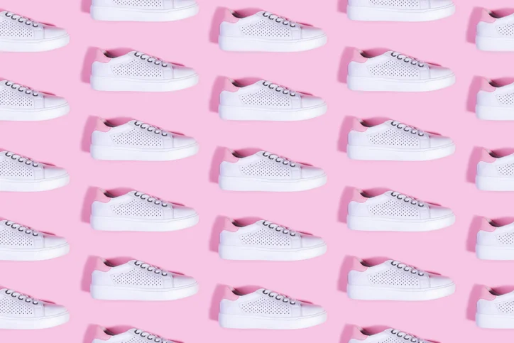 white sneakers on pink background