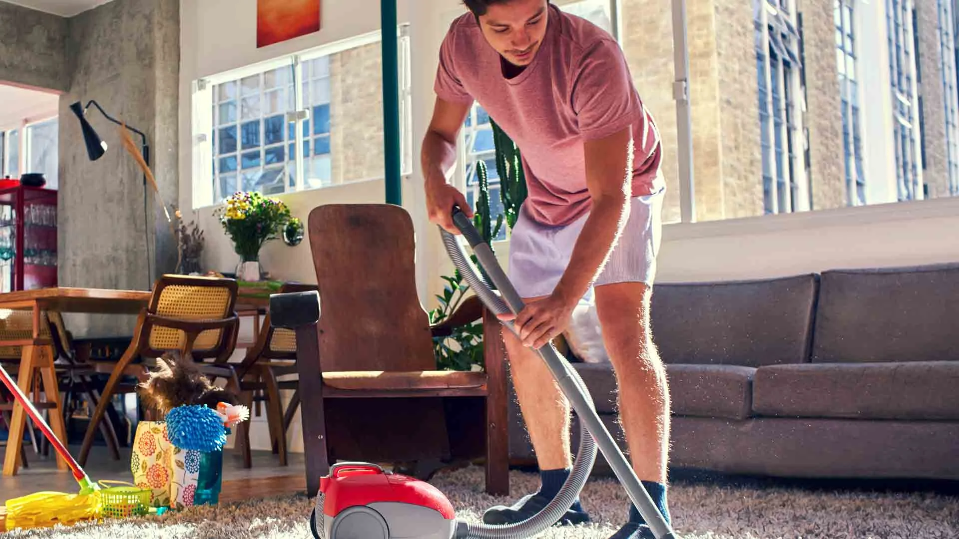 Young tenant hoovering prior to a landlord inspection.