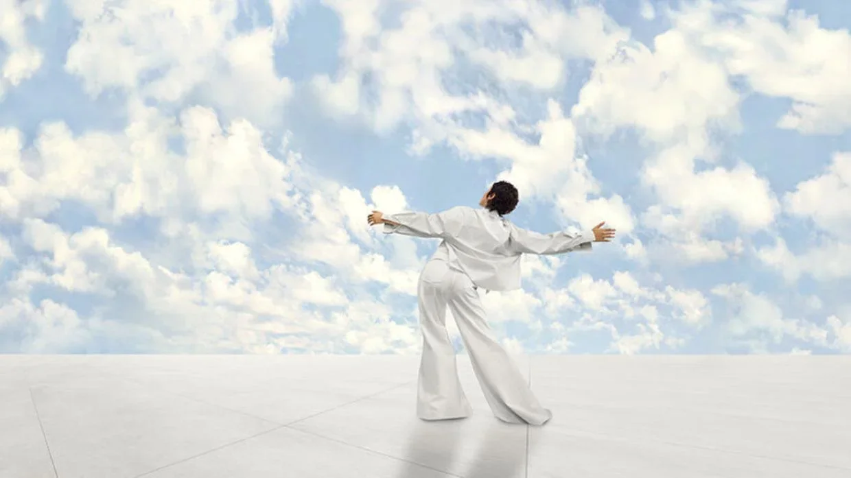 person dancing under clouds 