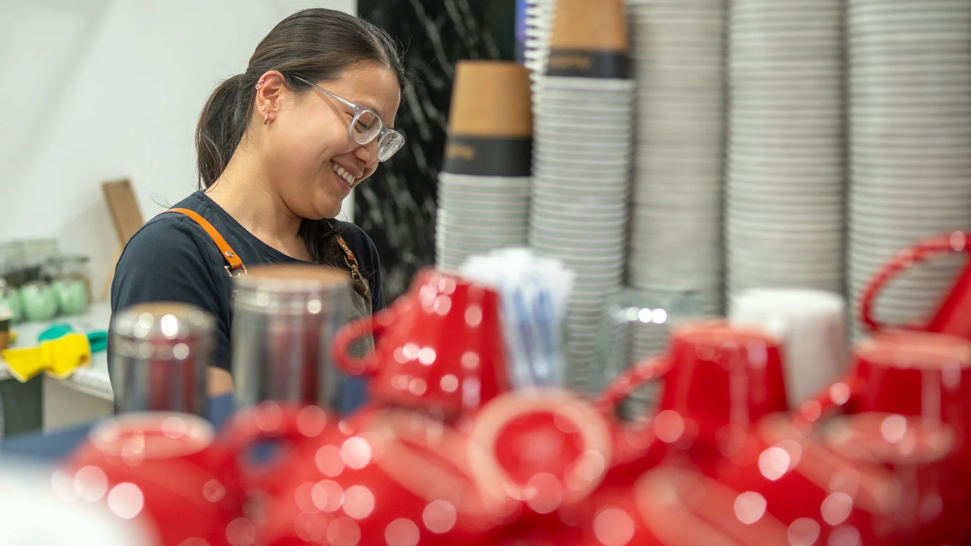 Young female employee working as a barista in a coffee shop in New Zealand.